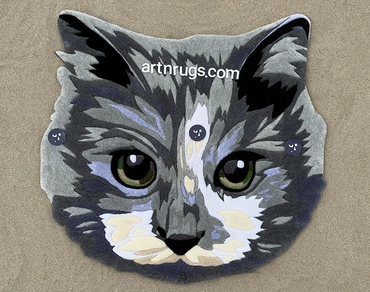 Handcrafted detailed gray cat face rug laid on sandy beach – realistic portrait design
