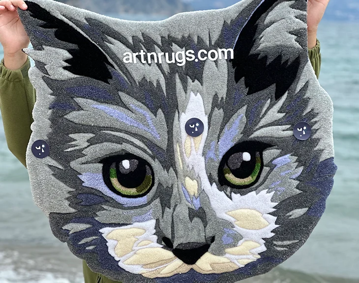 Close-up of handcrafted realistic gray cat face rug by the water front