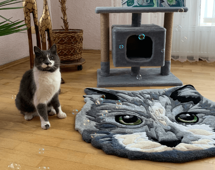 A gray cat sitting next to the realistic rug and a cat scratching post in a cozy interior