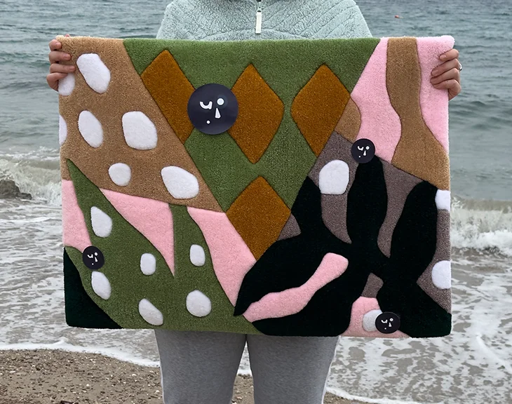 Moderner Tropenblatt-Teppich am Ufer präsentiert, hebt das geometrische Muster aus Rosa, Oliv und Senfgelb in handgefertigtem Acryl hervor