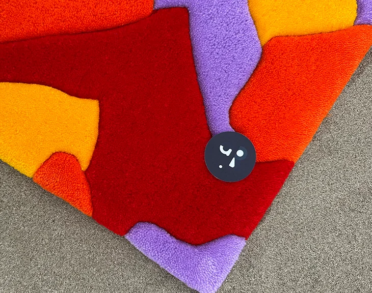 Gros plan sur les fibres acryliques texturées rouges et violettes du tapis
